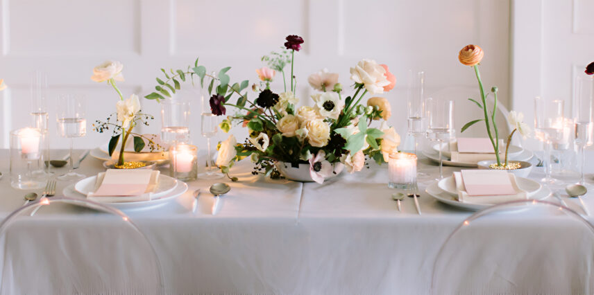 A floral arrangement sits amongst plates and cutlery