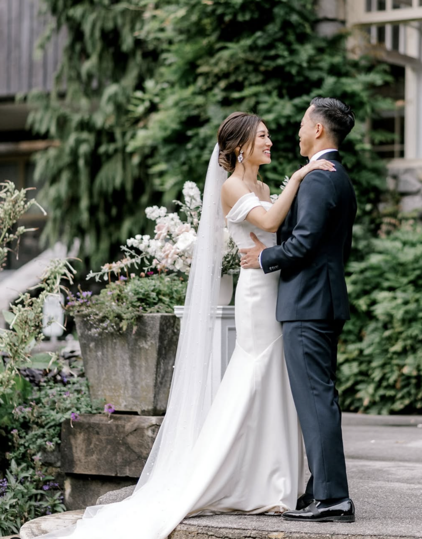 A couple embrace on the steps of the Stanley Park Pavilion