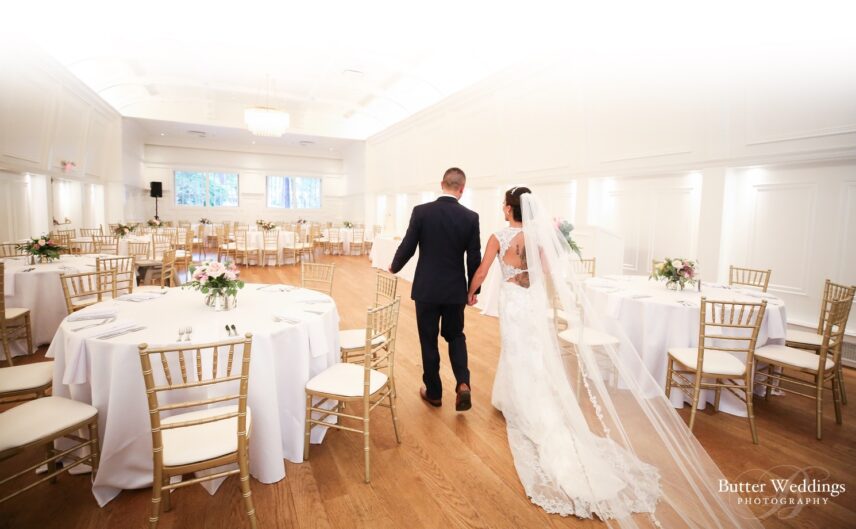 A newlywed couple tour the Ballroom in the Stanley Park Pavilion, set up to serve food to guests