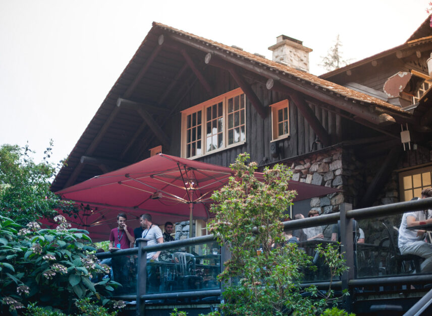 Guests enjoy the patio at Stanley's Bar and Grill, the sun is setting in the background, and people are mingling after a corporate event.