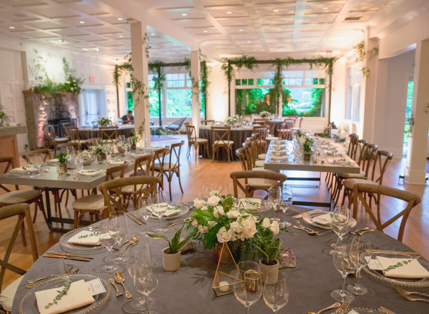 The Tea Room at the Stanley Park Pavilion set up for a wedding reception. Tables prepared with culinary settings, and flower centerpieces.