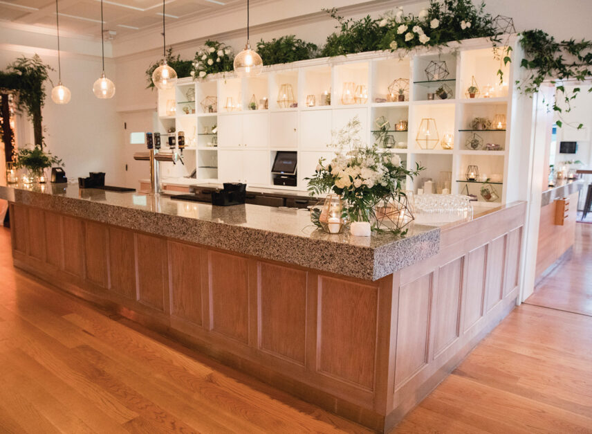 The bar in the Tea Room of the Stanley Park Pavilion, decorated for a wedding with flowers and stylistic lighting.