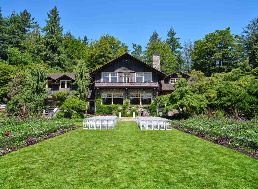 The Stanley Park Pavilion on a summer's day. Blue skies and green grass. Seats line the lawn awaiting the beginning of a ceremony