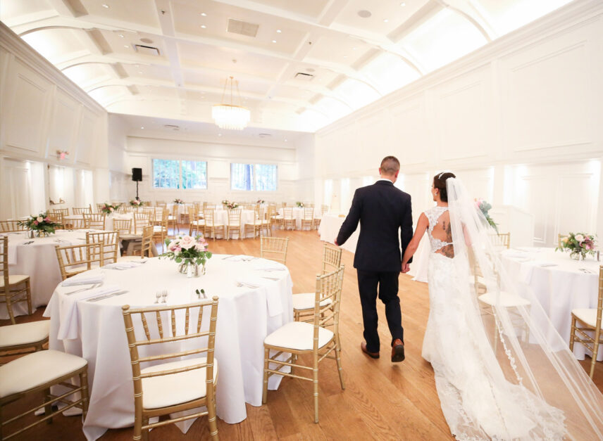 A newlywed couple tour the Ballroom in the Stanley Park Pavilion, set up to serve food to guests